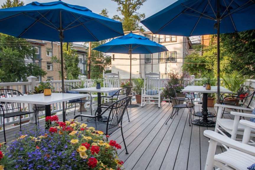 Eine Terrasse mit Tisch und Stühlen und blauen Regenschirmen