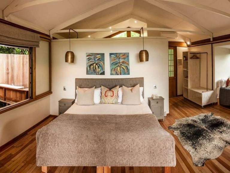 Ein Schlafzimmer mit einem Bett und zwei Gemälden an der Wand