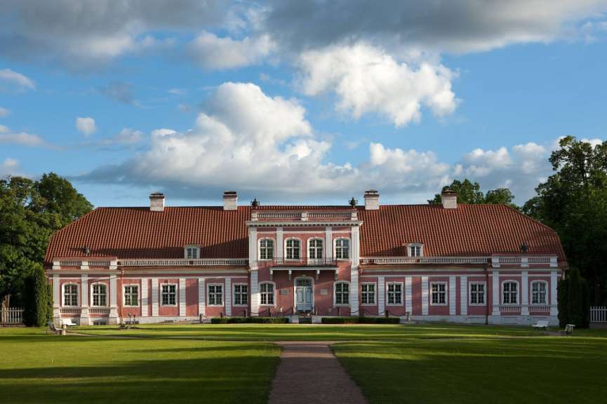 Ein großes rosa und weißes Gebäude mit einem roten Dach