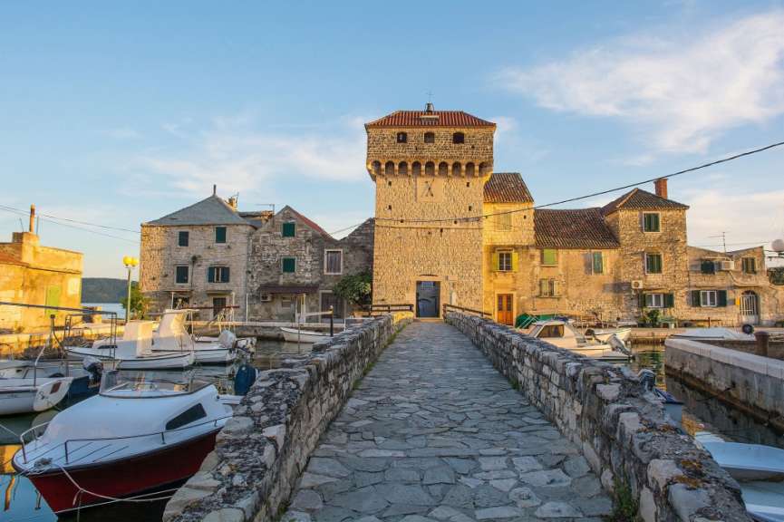 Eine Steinbrücke führt zu einem Gebäude mit einem Turm darauf