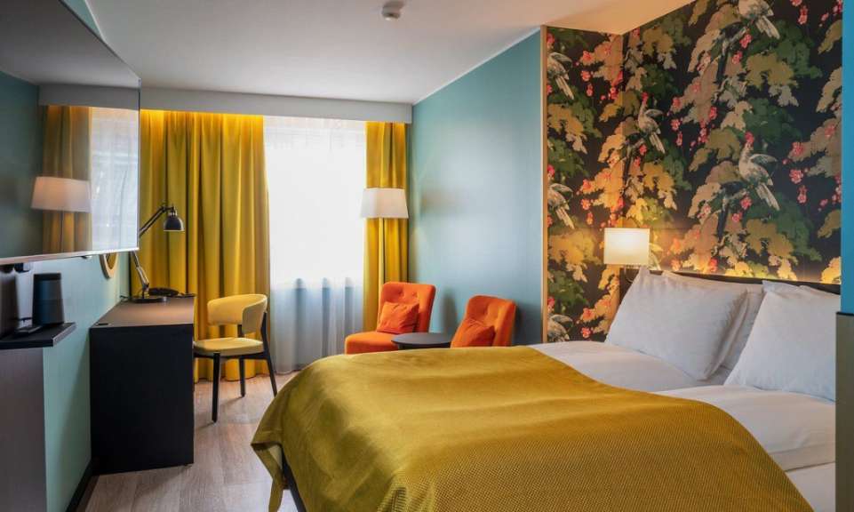 Ein Hotelzimmer mit einem Bett und zwei Stühlen
