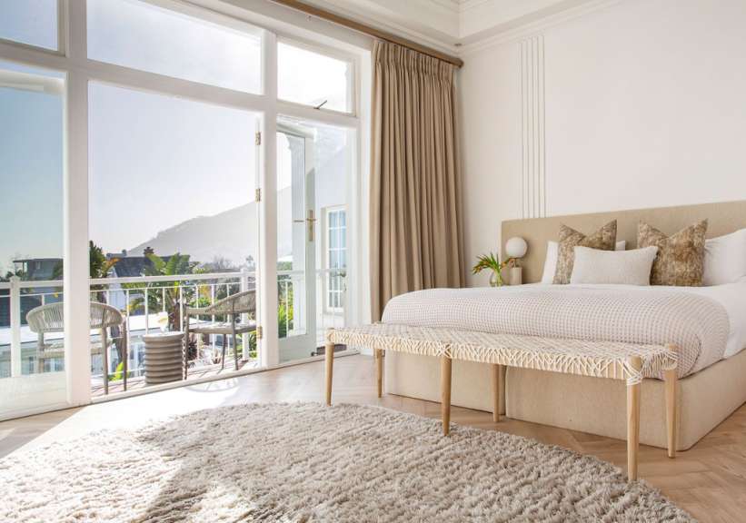Ein weißes Schlafzimmer mit einem Bett und einer Bank