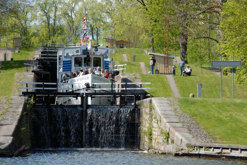 Ein blau-weißes Boot fährt durch eine Schleuse