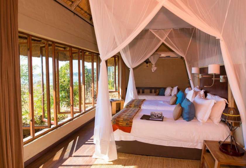 Ein Schlafzimmer mit zwei Betten und vielen Fenstern