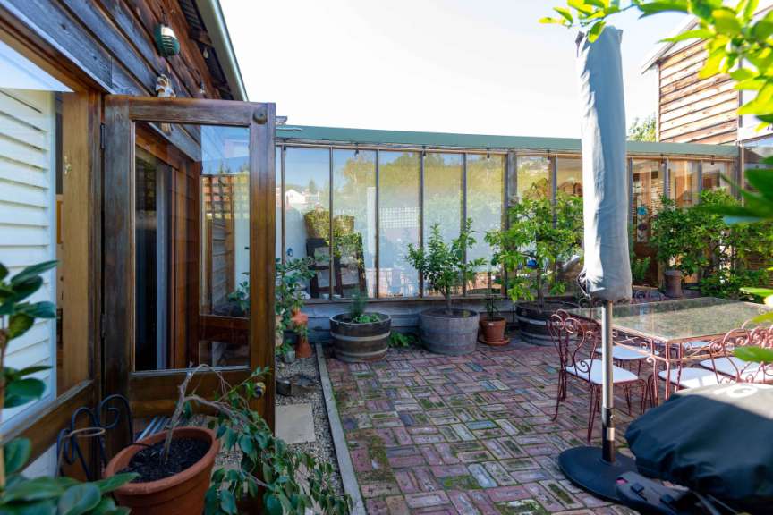 Eine Terrasse mit einem Tisch und Stühlen und einem Grill