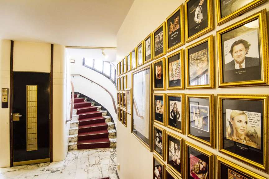 Ein Flur mit vielen Bildern an der Wand und einer Treppe