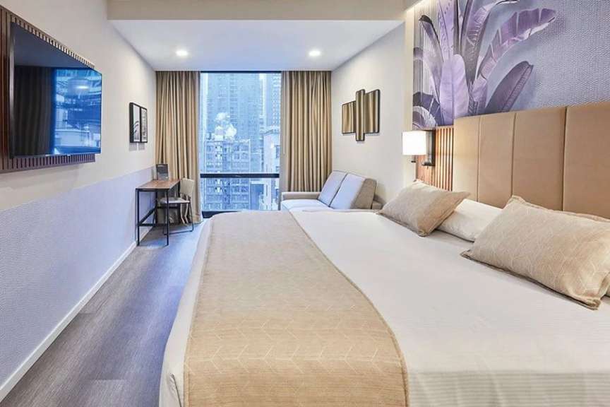 Ein Hotelzimmer mit einem Bett und einem Fernseher