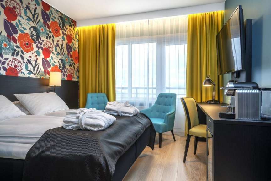 Ein Hotelzimmer mit einem Bett und zwei Stühlen
