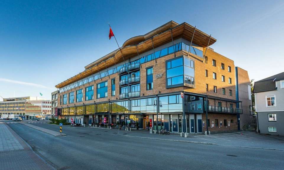 Ein großes Gebäude mit vielen Fenstern und der Aufschrift tcm