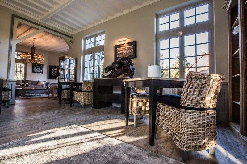 Ein Wohnzimmer mit Tisch und Stühlen und vielen Fenstern