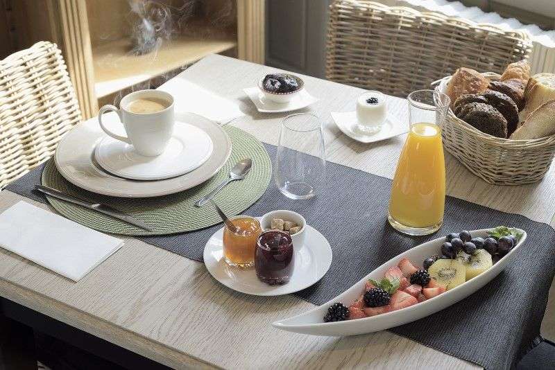 Ein tisch mit einem teller mit früchten und einer tasse kaffee
