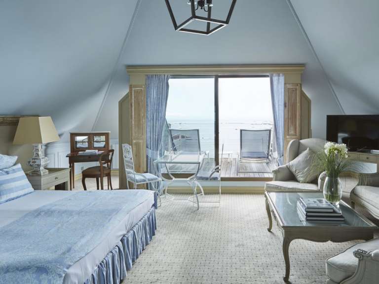 Ein Schlafzimmer mit einem Bett, einem Stuhl, einem Tisch und einem Fernseher