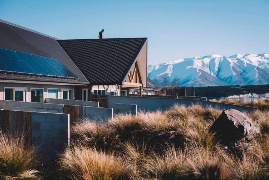 Ein Haus mit Sonnenkollektoren auf dem Dach und einem Berg im Hintergrund