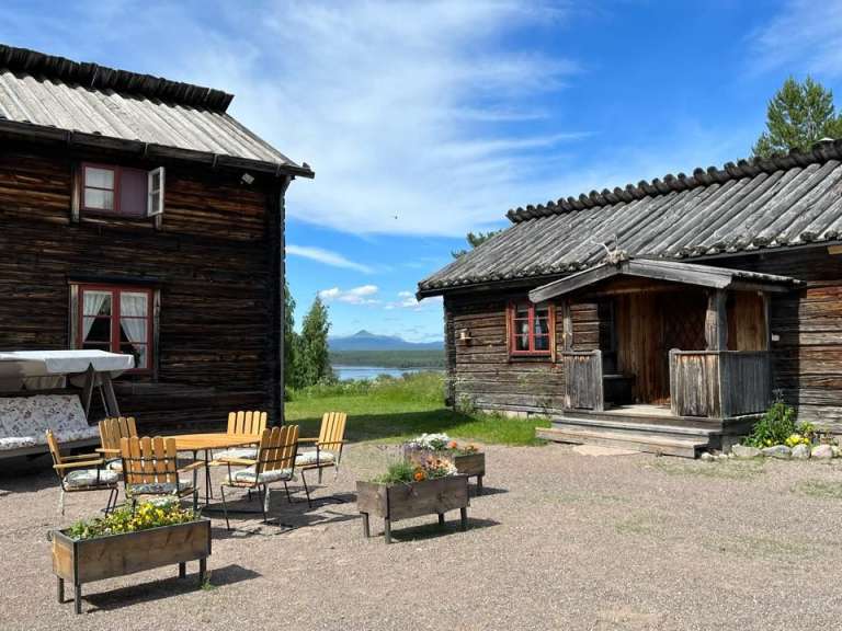 Ein Holzhaus mit einem Tisch und Stühlen davor