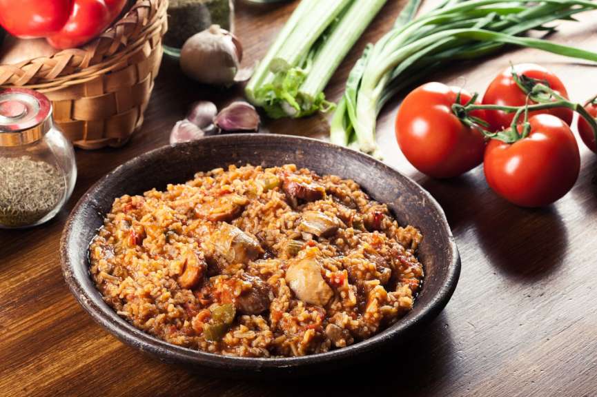 Eine Schüssel mit Reis und Gemüse steht auf einem Holztisch
