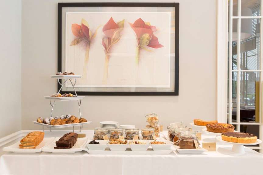 Ein Buffettisch mit verschiedenen Desserts und einem Gemälde an der Wand