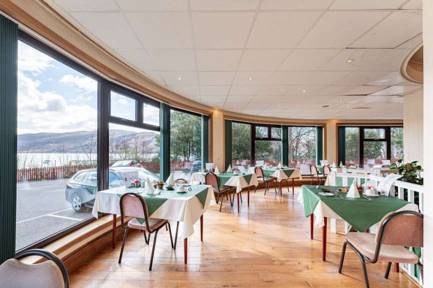 Tische und Stühle in einem Restaurant mit vielen Fenstern