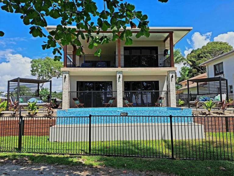 Ein Haus mit einem Pool und einem Zaun davor