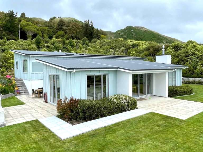 Ein blaues Haus mit einem schwarzen Dach und vielen Fenstern