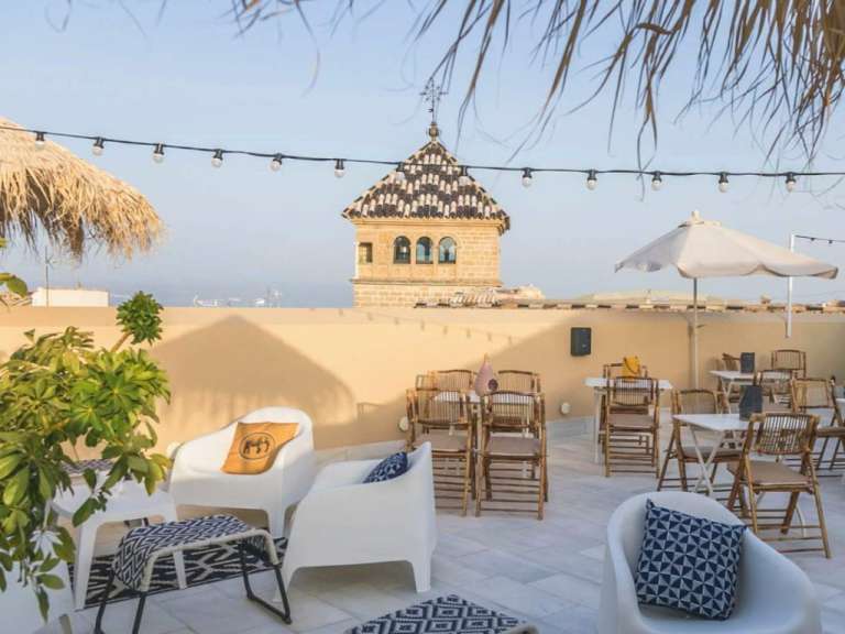 Eine Terrasse mit Stühlen und Tischen mit einem Turm im Hintergrund