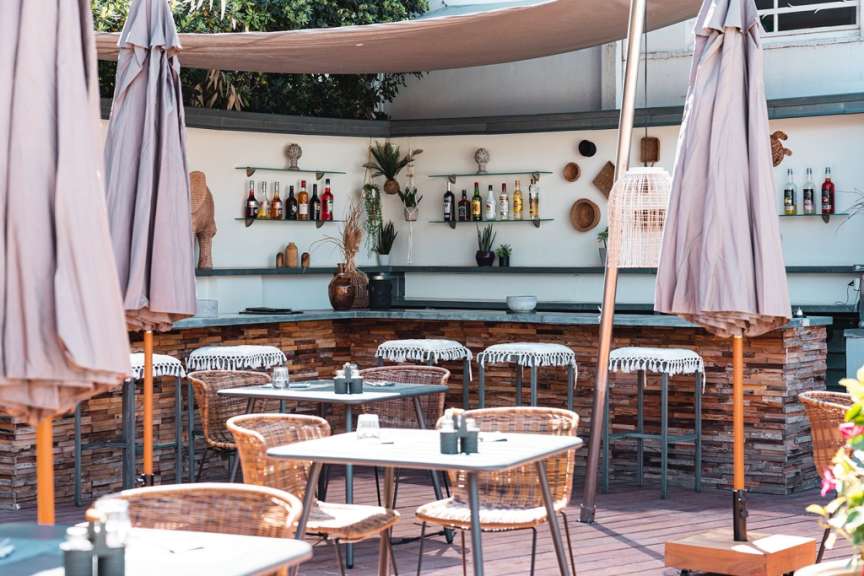 Tische und Stühle in einem Restaurant mit einer Bar im Hintergrund