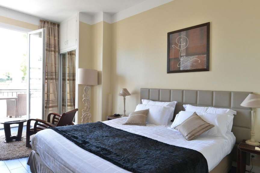 Ein Hotelzimmer mit einem großen Bett und einem Gemälde an der Wand