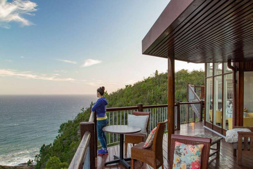 Eine Frau steht auf einem Deck mit Blick auf das Meer