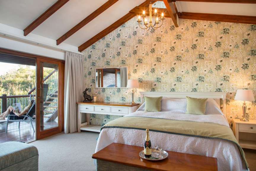 Ein Schlafzimmer mit einem Bett und einem Tisch mit einer Flasche Champagner darauf