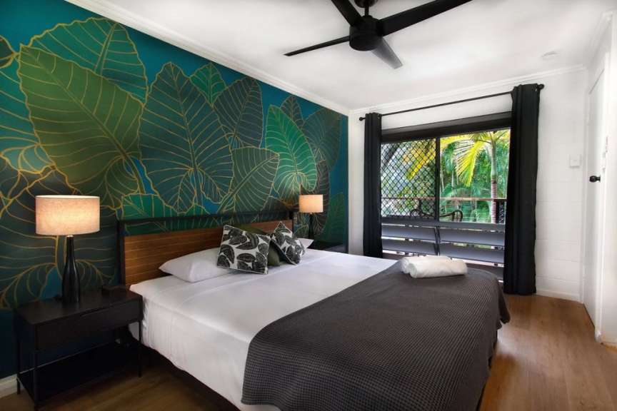 Ein Schlafzimmer mit einem Bett und einem Deckenventilator