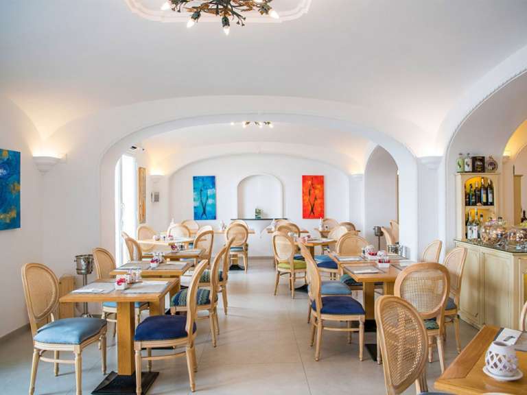 Ein Esszimmer mit vielen Tischen und Stühlen