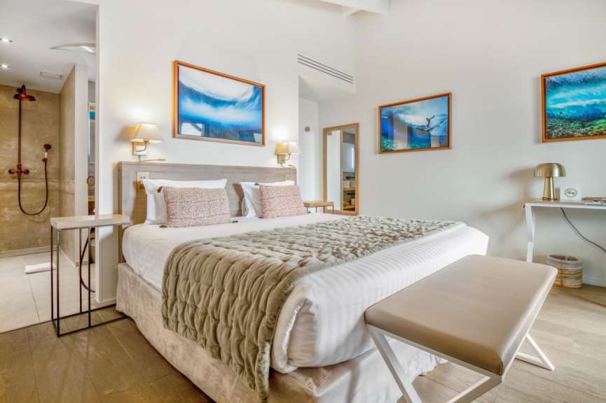 Ein Schlafzimmer mit einem Bett und zwei Bildern an der Wand
