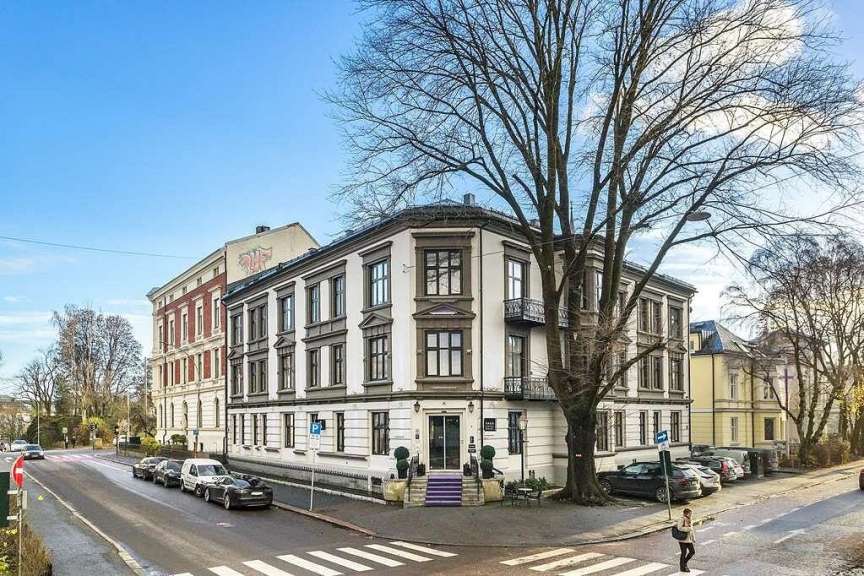 Eine Frau geht an einem Straßenkreuz vor einem großen weißen Gebäude
