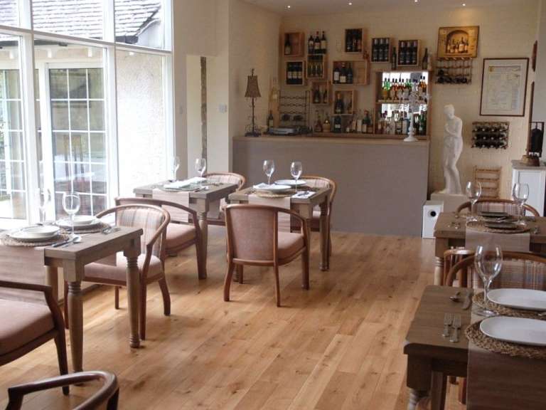 Ein Esszimmer mit Tischen und Stühlen und einer Bar