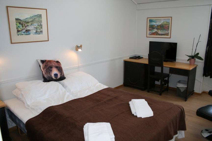 Ein Bett mit einem Bärenkissen darauf