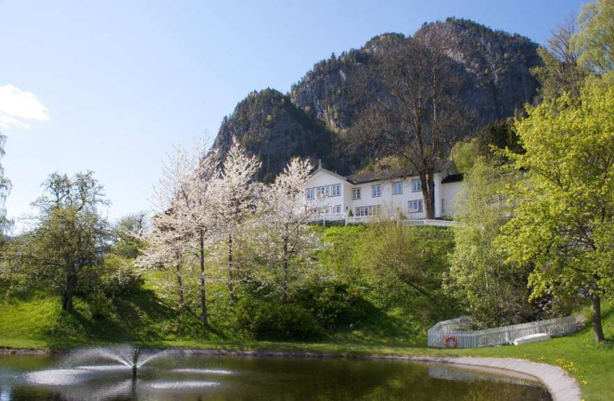 Ein Teich mit einem Brunnen und einem Gebäude im Hintergrund