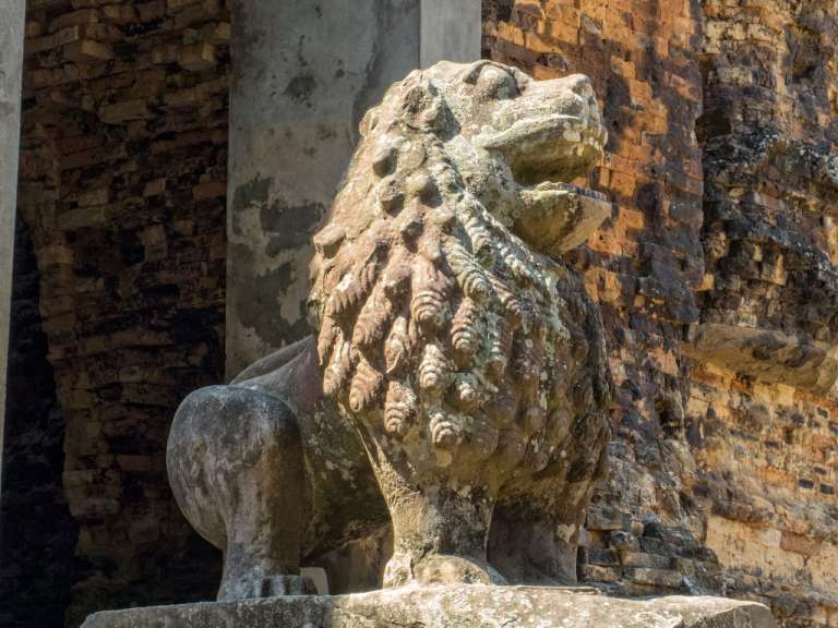 Eine Statue eines Löwen vor einer Backsteinmauer