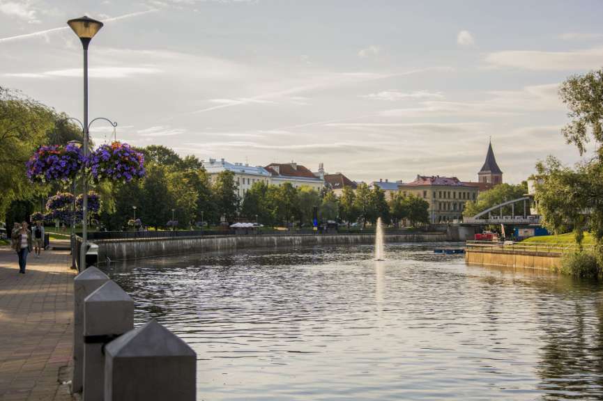 Ein Fluss mit einem Brunnen in der Mitte und Gebäuden im Hintergrund