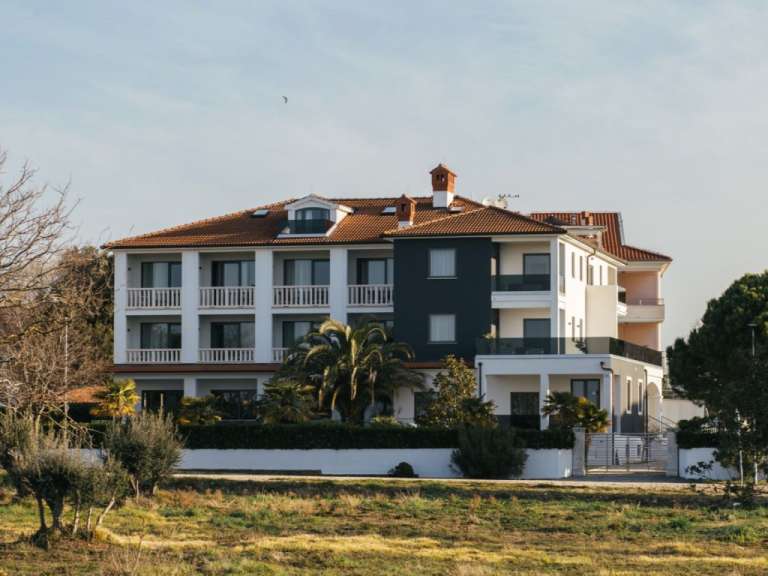 Ein großes schwarz-weißes Haus mit einem roten Dach