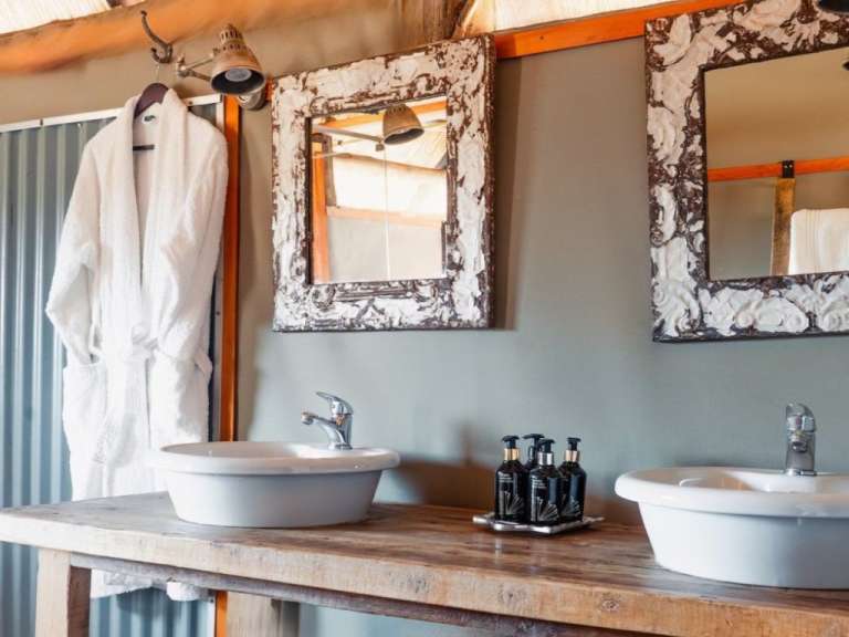 Ein Badezimmer mit zwei Waschbecken und zwei Spiegeln