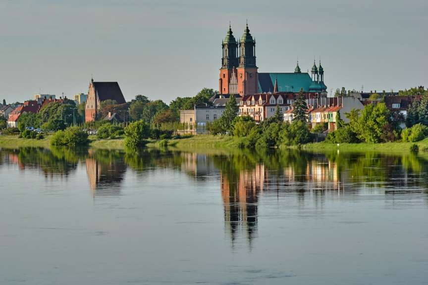 Eine Stadtlandschaft mit einem Fluss und einer Kirche im Hintergrund