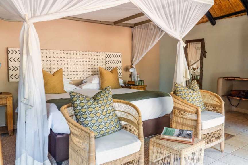Ein Schlafzimmer mit einem Himmelbett und zwei Stühlen