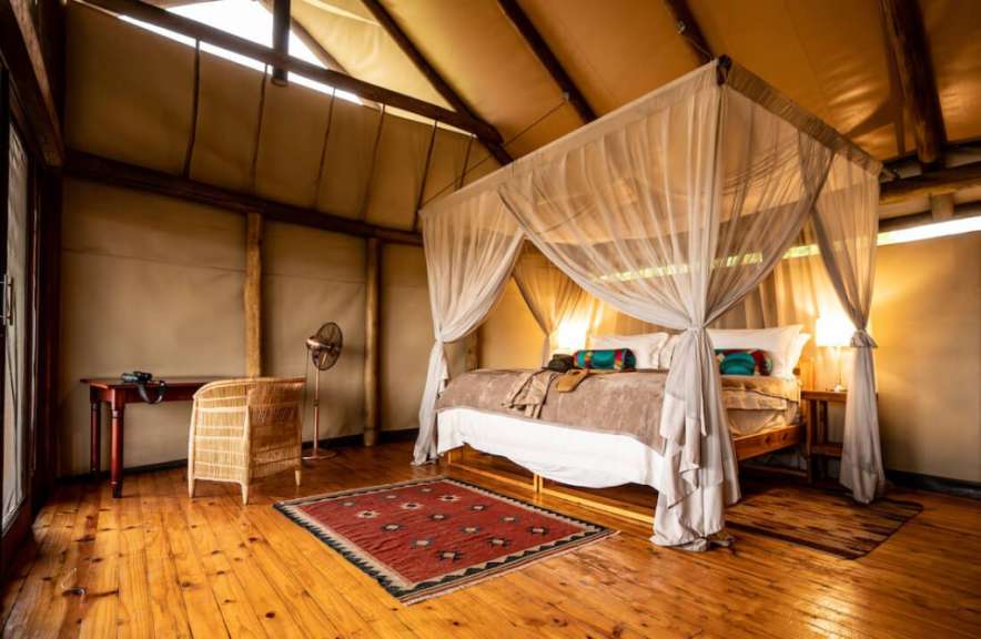 Ein Schlafzimmer mit einem Himmelbett und einem roten Teppich
