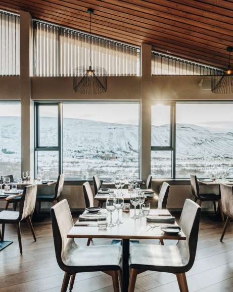 Ein gemütliches Restaurant mit Blick auf eine verschneite Berglandschaft.