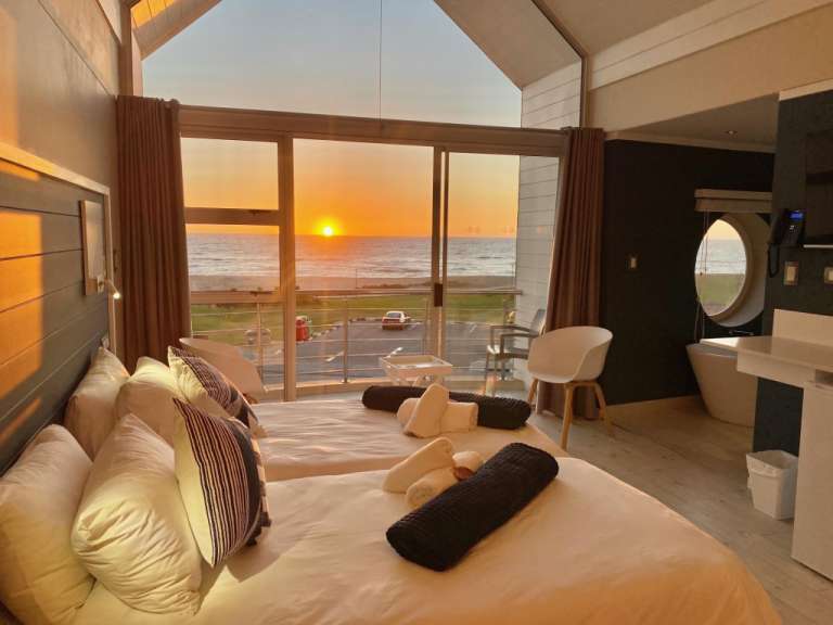 Ein Hotelzimmer mit Blick auf das Meer bei Sonnenuntergang