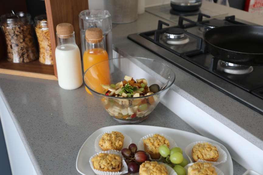 Eine Küche mit einem Teller mit Cupcakes und einer Schüssel Obstsalat