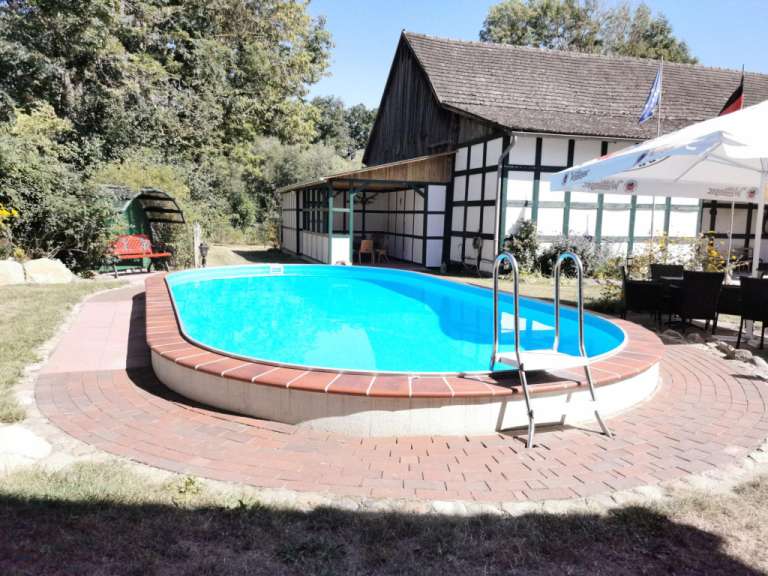 Ein großer blauer Pool mit einem weißen Regenschirm darauf