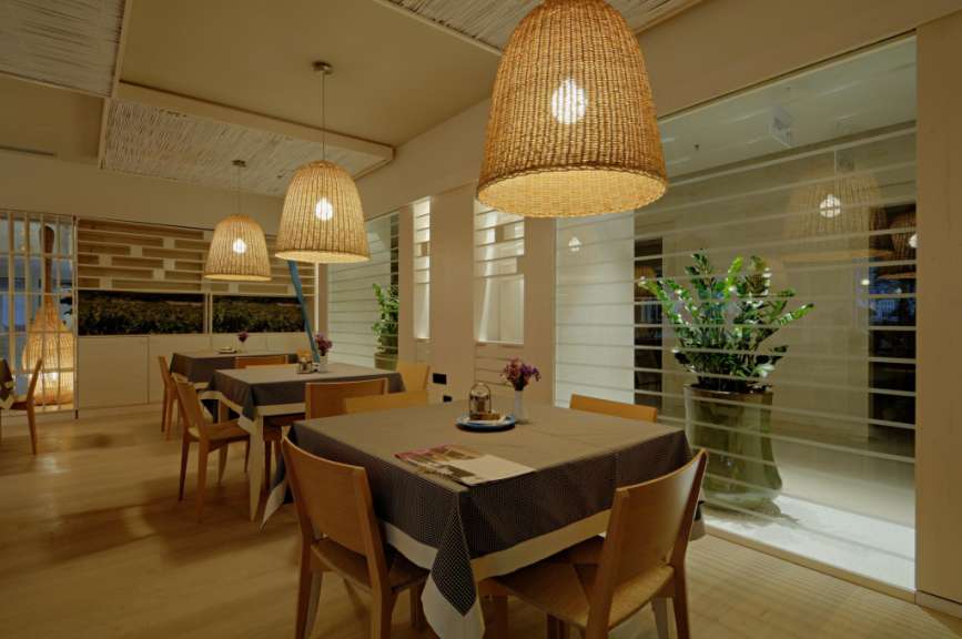 Ein Esszimmer mit Tischen und Stühlen und Lampen