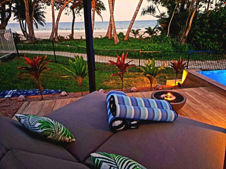 Eine Terrasse mit einer Feuerstelle und einem Strand im Hintergrund