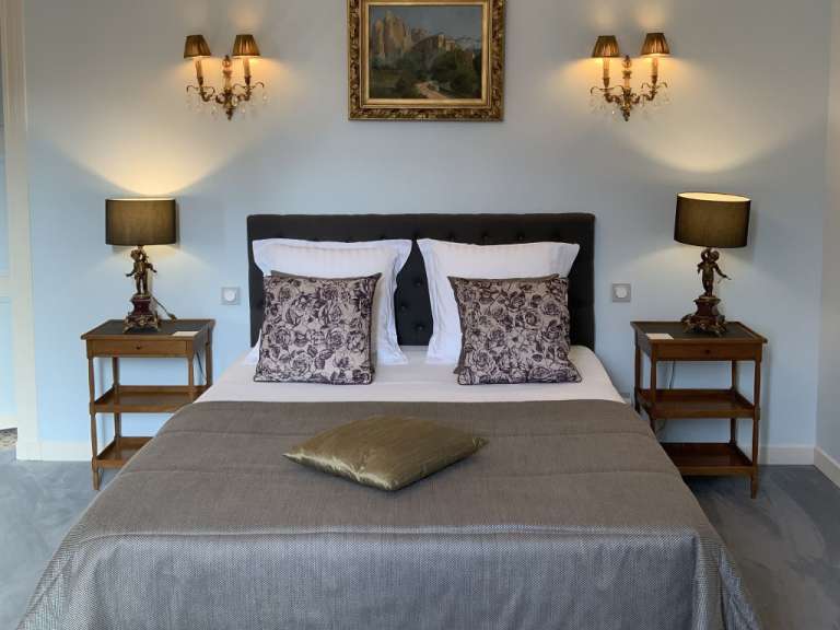 Ein Schlafzimmer mit zwei Nachttischen und einem Gemälde an der Wand