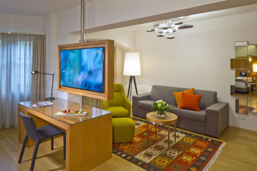 Ein Wohnzimmer mit einem Fernseher und einem Schreibtisch